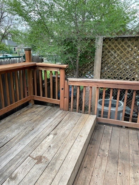 A wooden deck with a lattice fence and a hot tub.