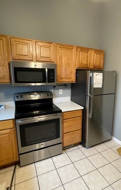 A kitchen with a stove, oven, microwave, and refrigerator.