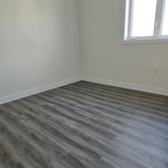 A room with a grey floor and a window.