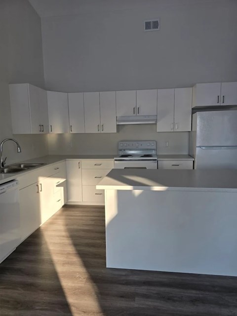 A kitchen with white cabinets and appliances.