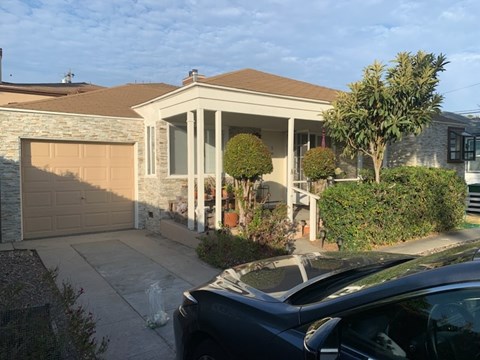 A house with a car parked in front.