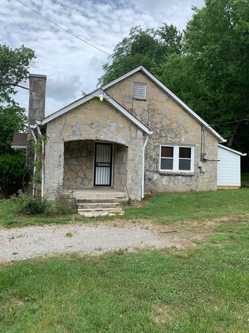 A small stone house with a white door and a window.