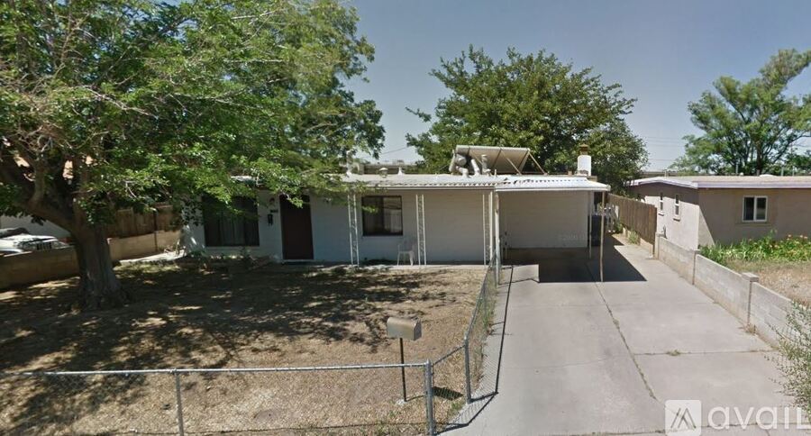 A house with a driveway and a tree in front.