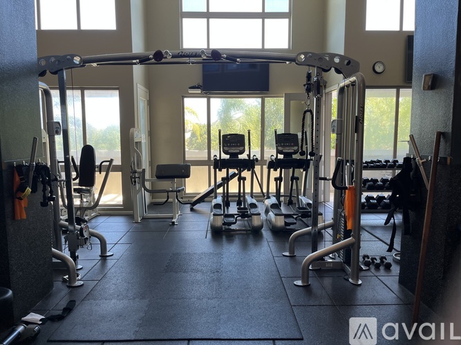A gym with a variety of equipment including treadmills, weights, and exercise machines.