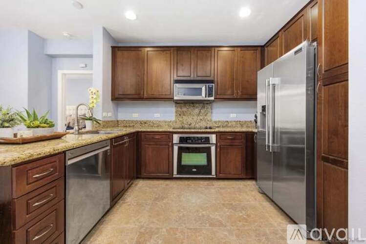 A kitchen with brown cabinets and stainless steel appliances.