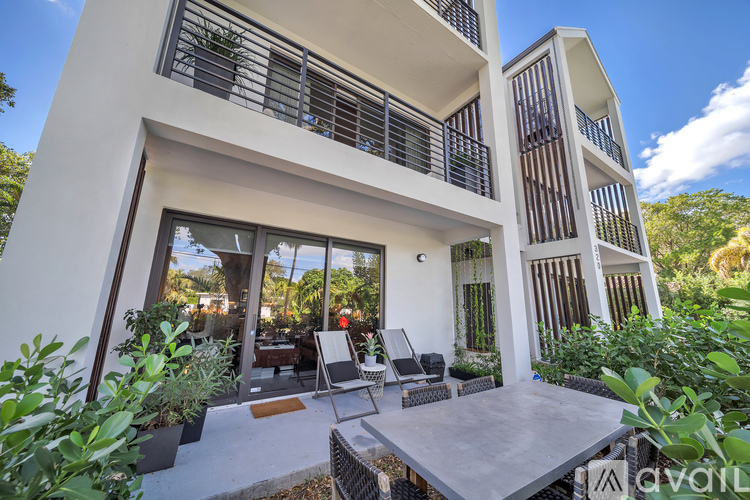 A modern house with a balcony and a patio table.