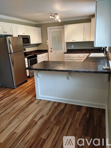 A kitchen with a refrigerator, microwave, and oven.