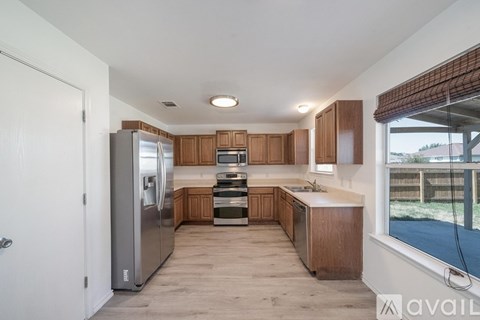 A kitchen with wooden cabinets and a stainless steel refrigerator.