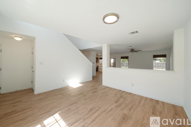 A spacious room with wooden floors and white walls.