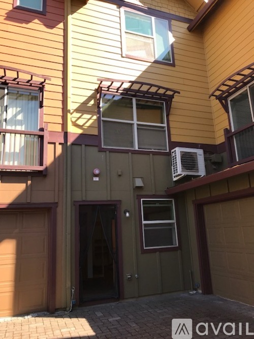 A house with a balcony and a garage door.