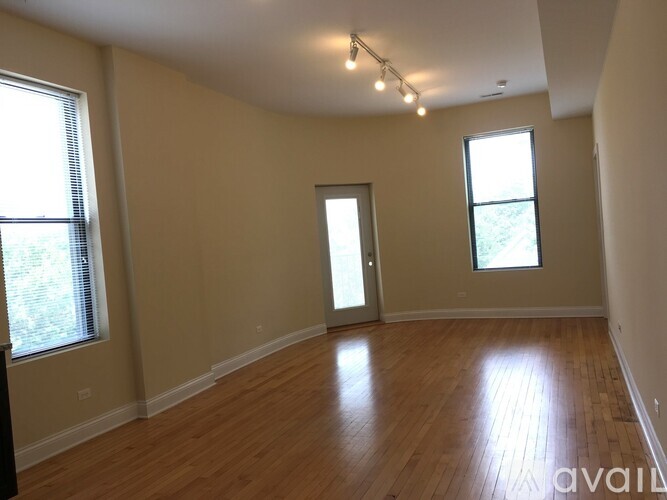 A room with wooden floors and a doorway leading to another room.
