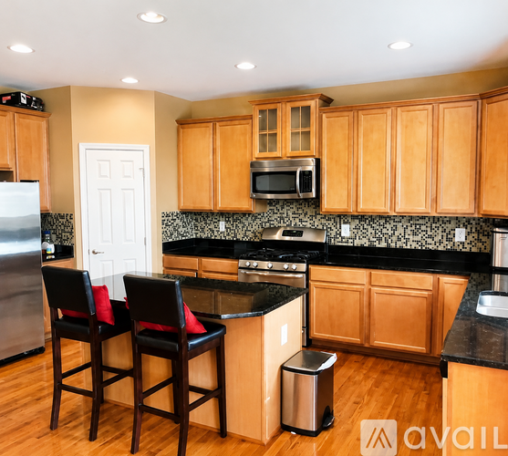 A kitchen with wooden cabinets and black countertops.