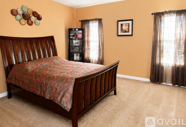 A bedroom with a bed, dresser, and window.
