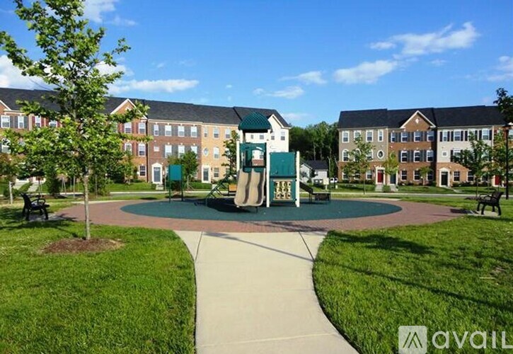 A playground with a green slide and a building in the background.