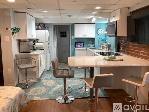 A kitchen with a white table and chairs.