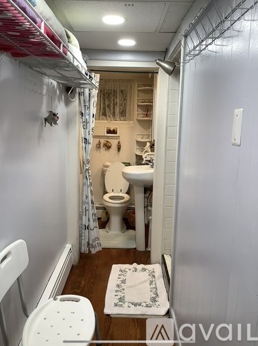 A small bathroom with a toilet, sink, and a rug on the floor.