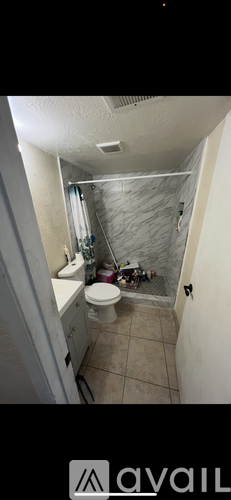 A bathroom with a toilet, sink, and shower.
