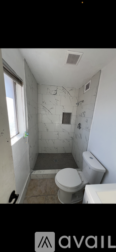 A bathroom with a toilet, sink, and shower.