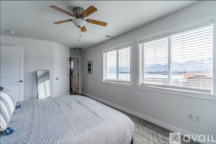 A bedroom with a large bed and a ceiling fan.
