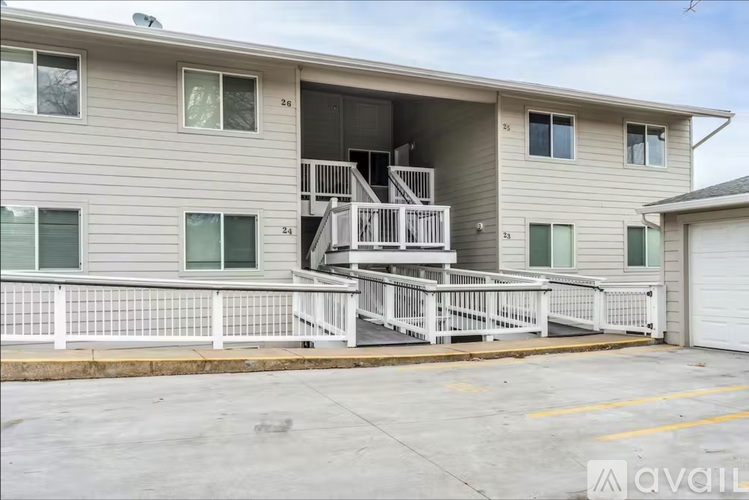 A two-story apartment building with a balcony and a garage.