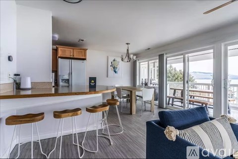 A kitchen with a bar area and a dining table with chairs.