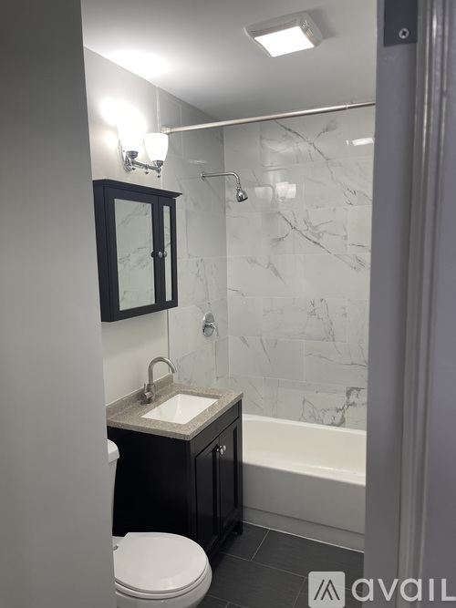 A bathroom with a marble shower and a toilet.