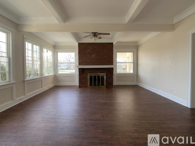 A spacious room with a fireplace and a ceiling fan.