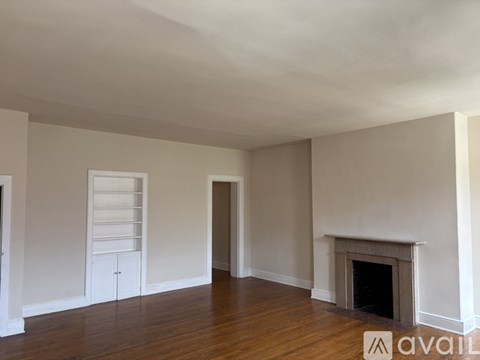 A room with a white door and a wooden floor.