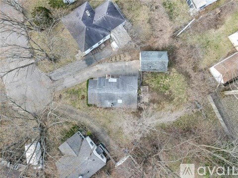 A bird's eye view of a property with a large grey building in the center.