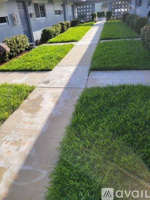 A sidewalk in front of a row of houses.