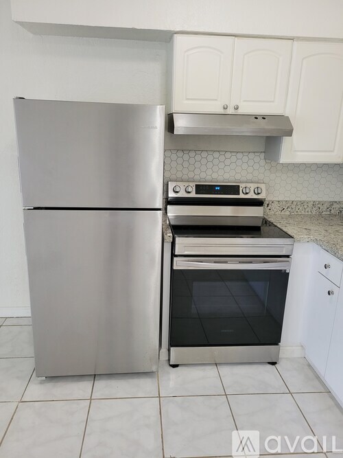 A stainless steel refrigerator and oven in a kitchen.