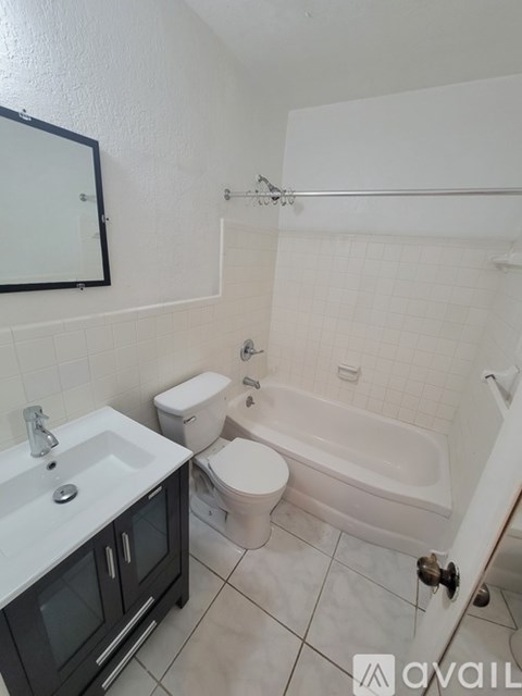 A bathroom with a toilet, sink, and bathtub.