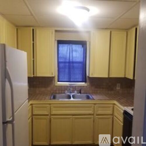A kitchen with yellow cabinets and a white refrigerator.