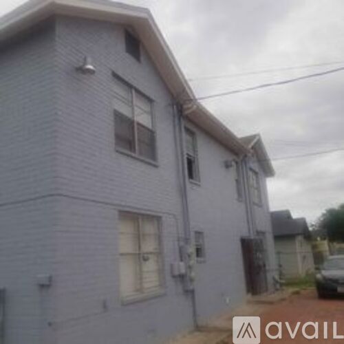 A grey house with a car parked in front.
