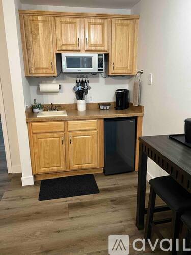 A kitchen with wooden cabinets and a black dishwasher.