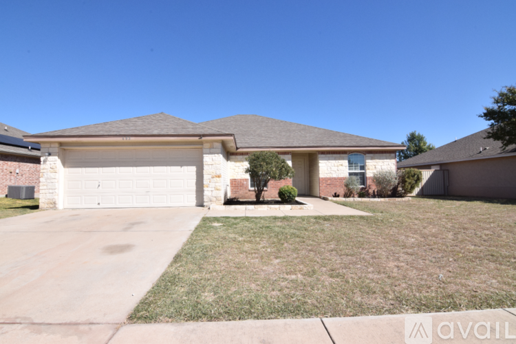 A house with a garage and a driveway in front.