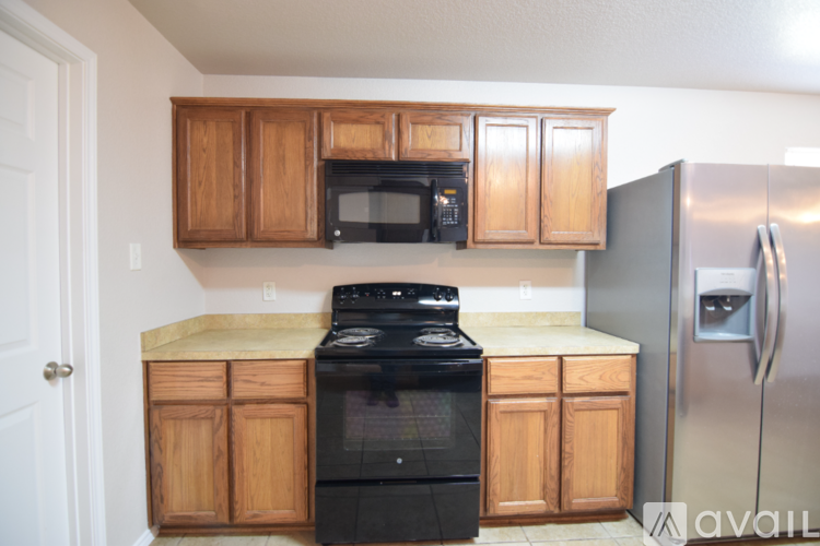 A kitchen with wooden cabinets and a black stove top oven.
