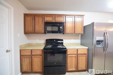 A kitchen with wooden cabinets and a black stove top oven.