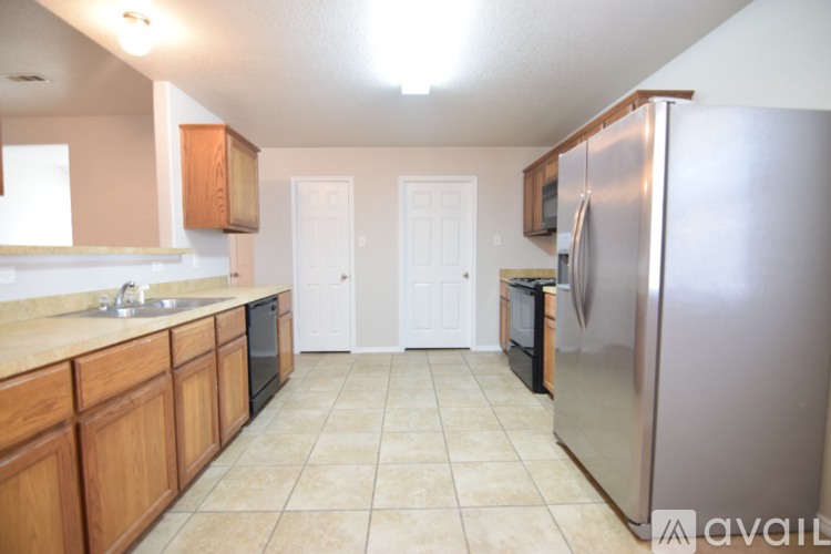 A kitchen with wooden cabinets and a stainless steel refrigerator.