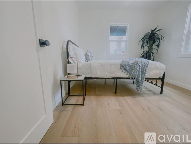 A bedroom with a bed and a plant.