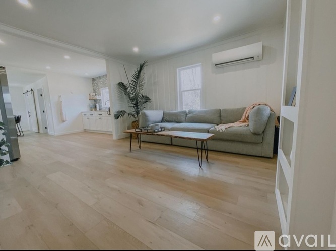 A living room with a grey sofa and wooden flooring.