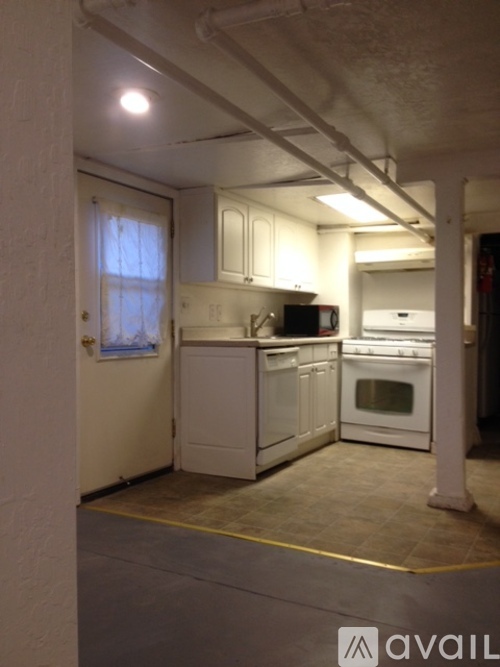 A kitchen with white appliances and cabinets.