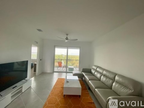 A living room with a grey leather sofa and a flat screen TV.
