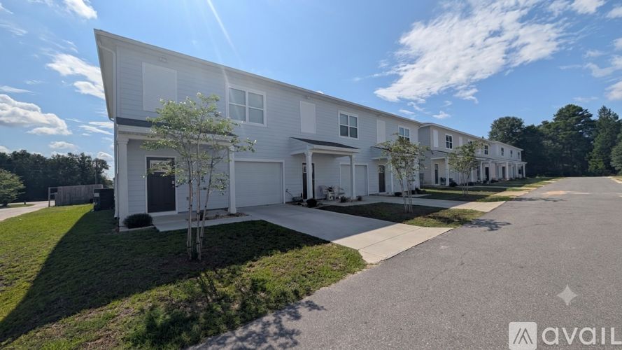 A row of white houses with a clear blue sky above them.