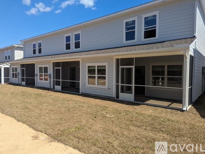 A row of houses with white siding and multiple windows.