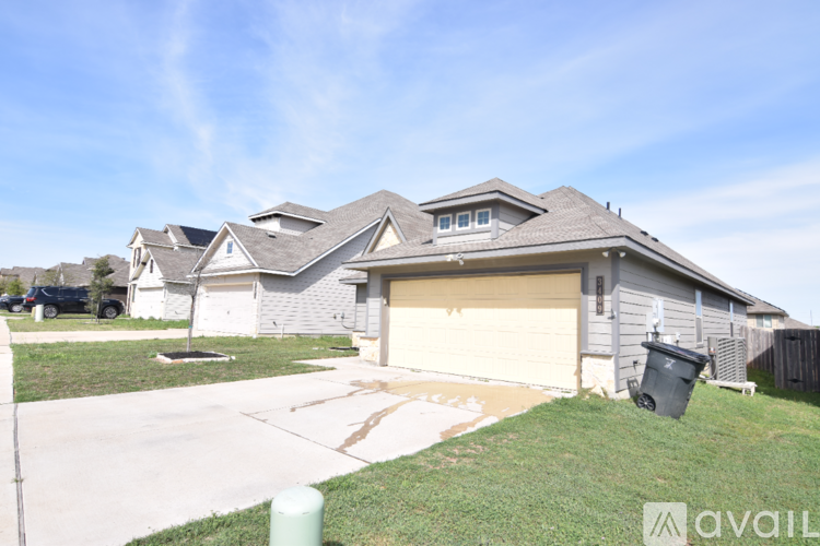 A house with a garage and a driveway in front of it.
