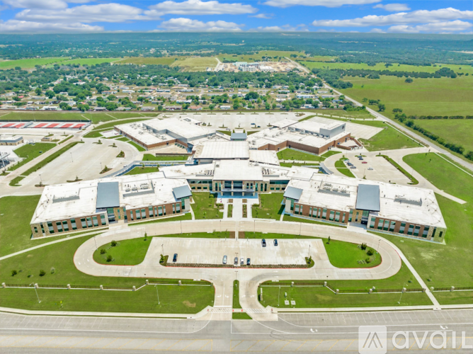 An aerial view of a large building complex surrounded by a green landscape.
