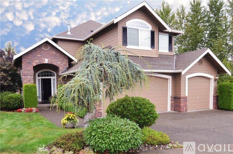 A house with a brown roof and a driveway in front.