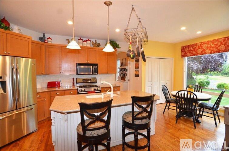 A kitchen with wooden cabinets and a white island.