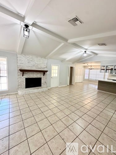 A spacious living room with a fireplace and tiled flooring.